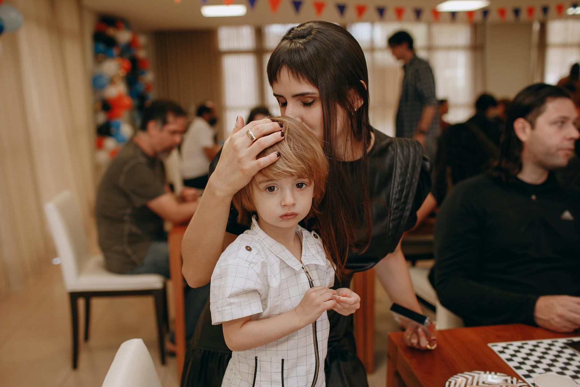 Mama przytula zasmucone dziecko podczas rodzinnego spotkania w domu
